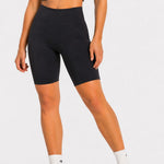 Rear angle of black cycling shorts on model, fitted mid length