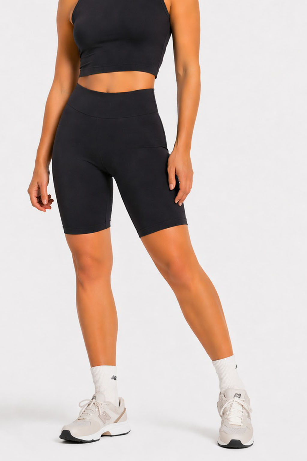 Rear angle of black cycling shorts on model, fitted mid length
