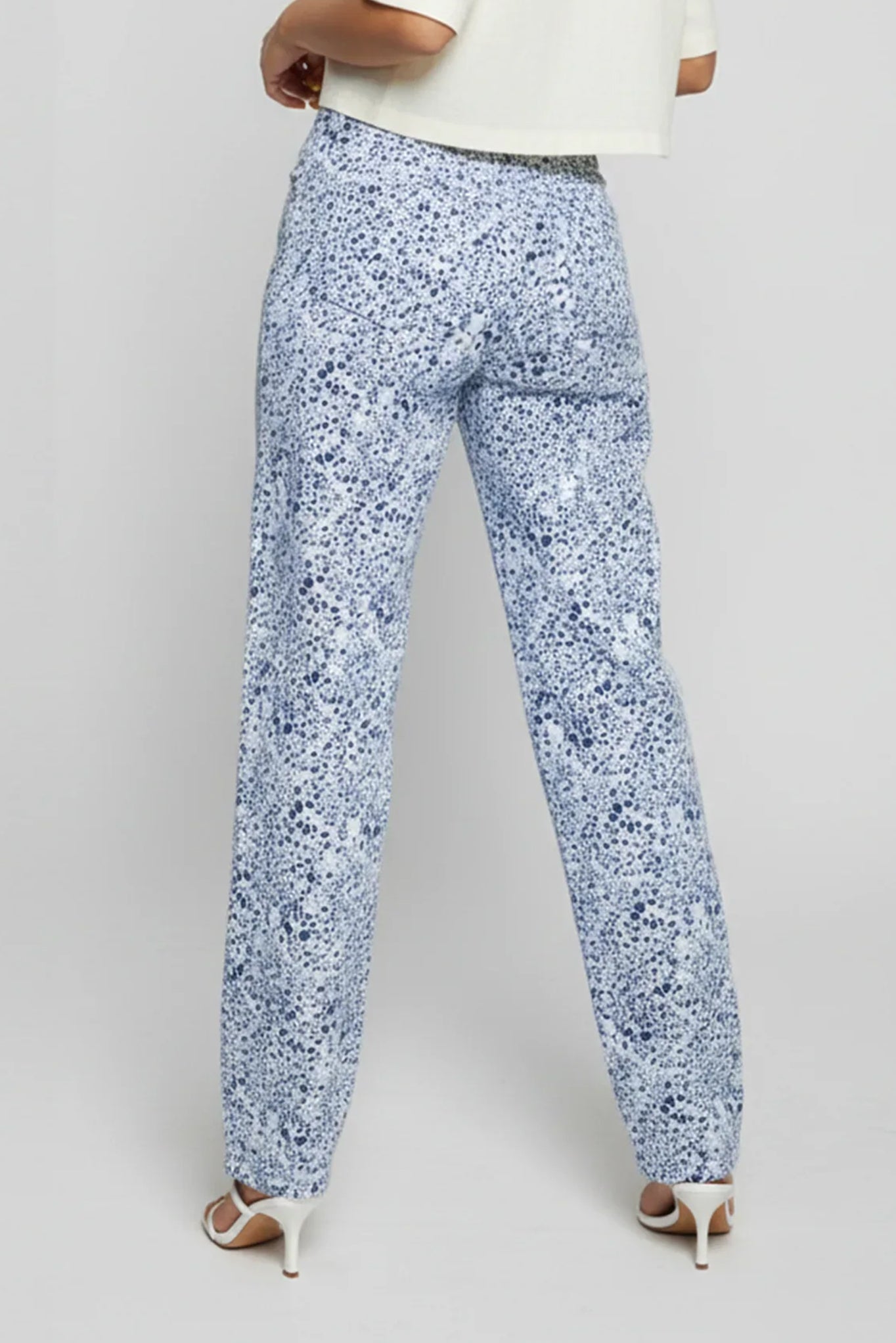 Blue floral pants worn by a person on a gray background