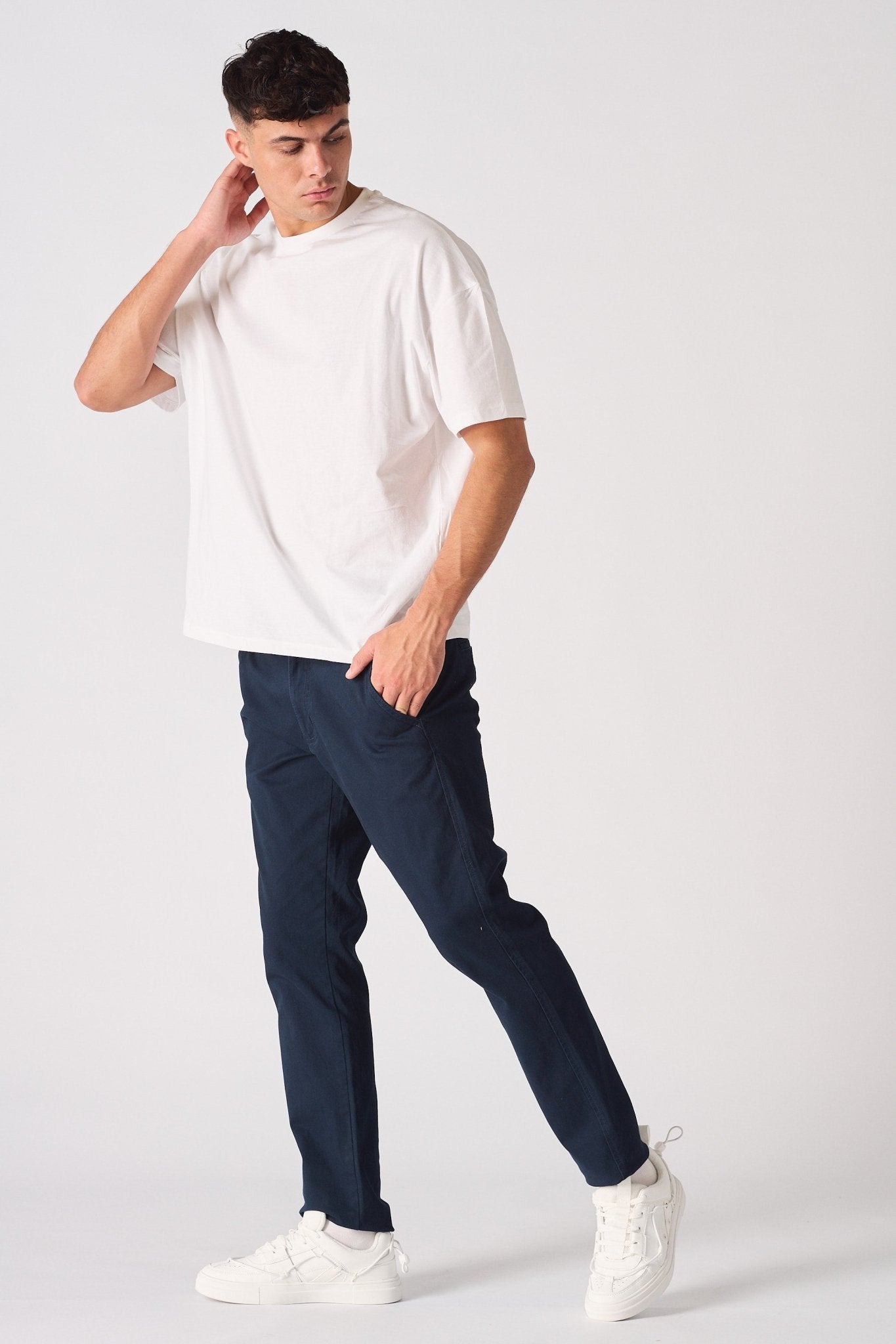 Side view of a male model wearing navy blue chinos slim fit.