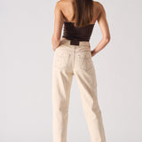 Woman wearing a strapless top and beige pants on a white background