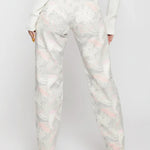 Full back view of a model wearing abstract swirl pattern high-rise jeans with classic back patch pockets.