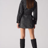 Back view of a model wearing the acid wash denim dress, highlighting the belt and panel details