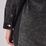 Close-up showing the sleeve cuff and dark side panel on the acid wash denim dress