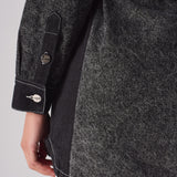 Close-up showing the sleeve cuff and dark side panel on the acid wash denim dress