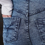 Close-up of the embroidered back pocket detail on the acid wash jeans