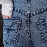 Close-up of the embroidered back pocket detail on the acid wash jeans