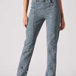 Person wearing acid-wash jeans on a plain background