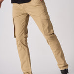 A model posing in beige cotton cargo pants showing the flexibility of the stretch fabric.