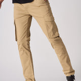 A model posing in beige cotton cargo pants showing the flexibility of the stretch fabric.
