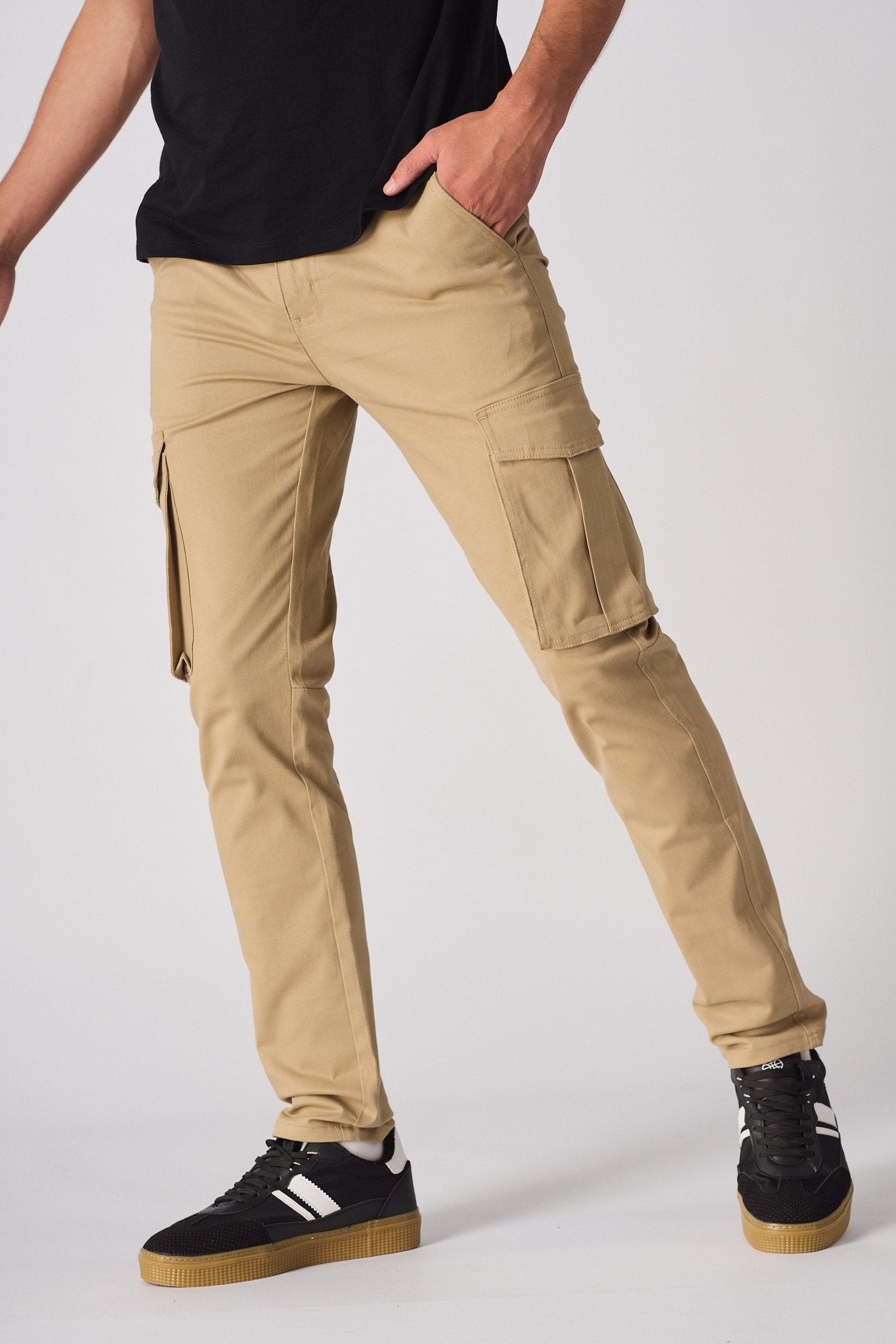 A model posing in beige cotton cargo pants showing the flexibility of the stretch fabric.