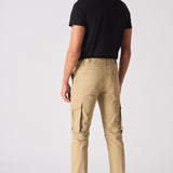 Rear view of a man wearing beige cotton cargo pants with visible back pockets.