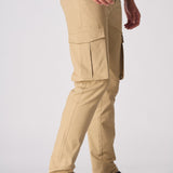 Side profile of a model wearing beige cotton cargo pants showing the functional side pockets.