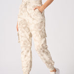 Side profile of women in beige tie dye cuffed cargo joggers