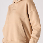Front view of a beige hoodie for women with a comfortable oversized design