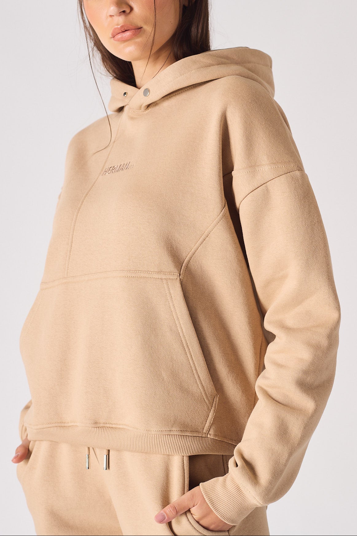 Front view of a beige hoodie for women with a comfortable oversized design