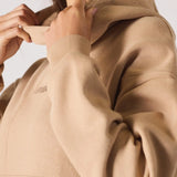 Side view of the popper neck and shoulder of a beige hoodie womens style