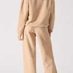 Rear view of an oversized beige hoodie for women showing the hood and relaxed fit