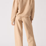 Rear view of an oversized beige hoodie for women showing the hood and relaxed fit