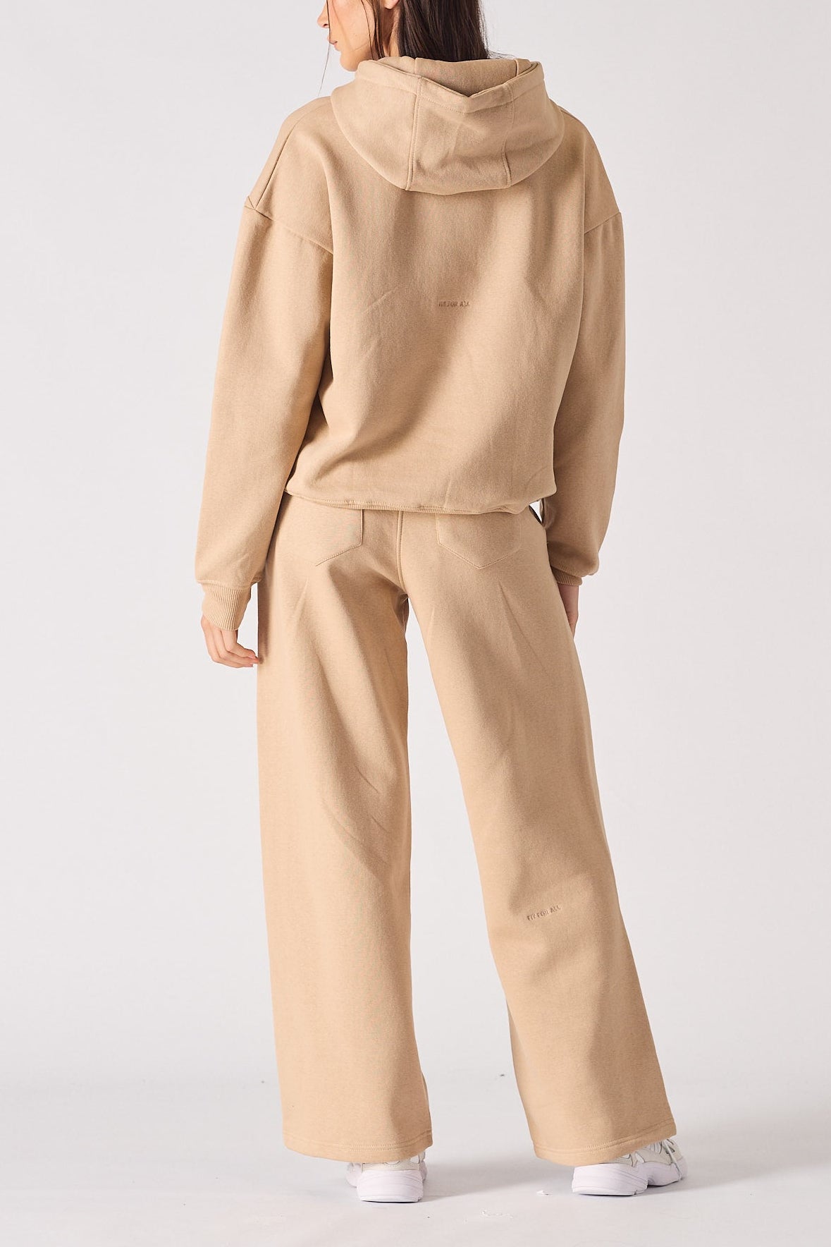 Rear view of an oversized beige hoodie for women showing the hood and relaxed fit