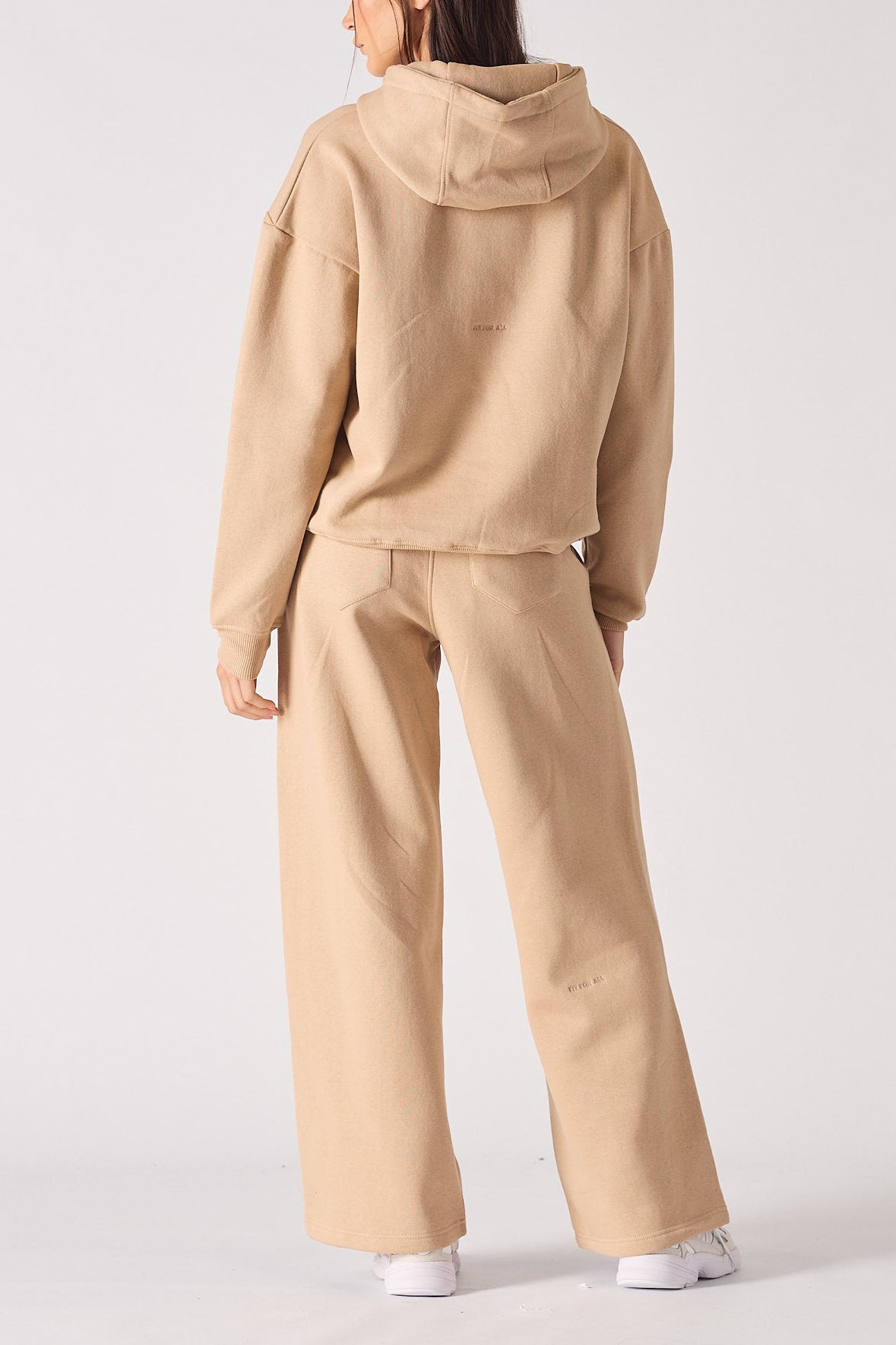 Rear view of an oversized beige hoodie for women showing the hood and relaxed fit