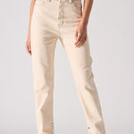 Person wearing beige jeans on a plain background