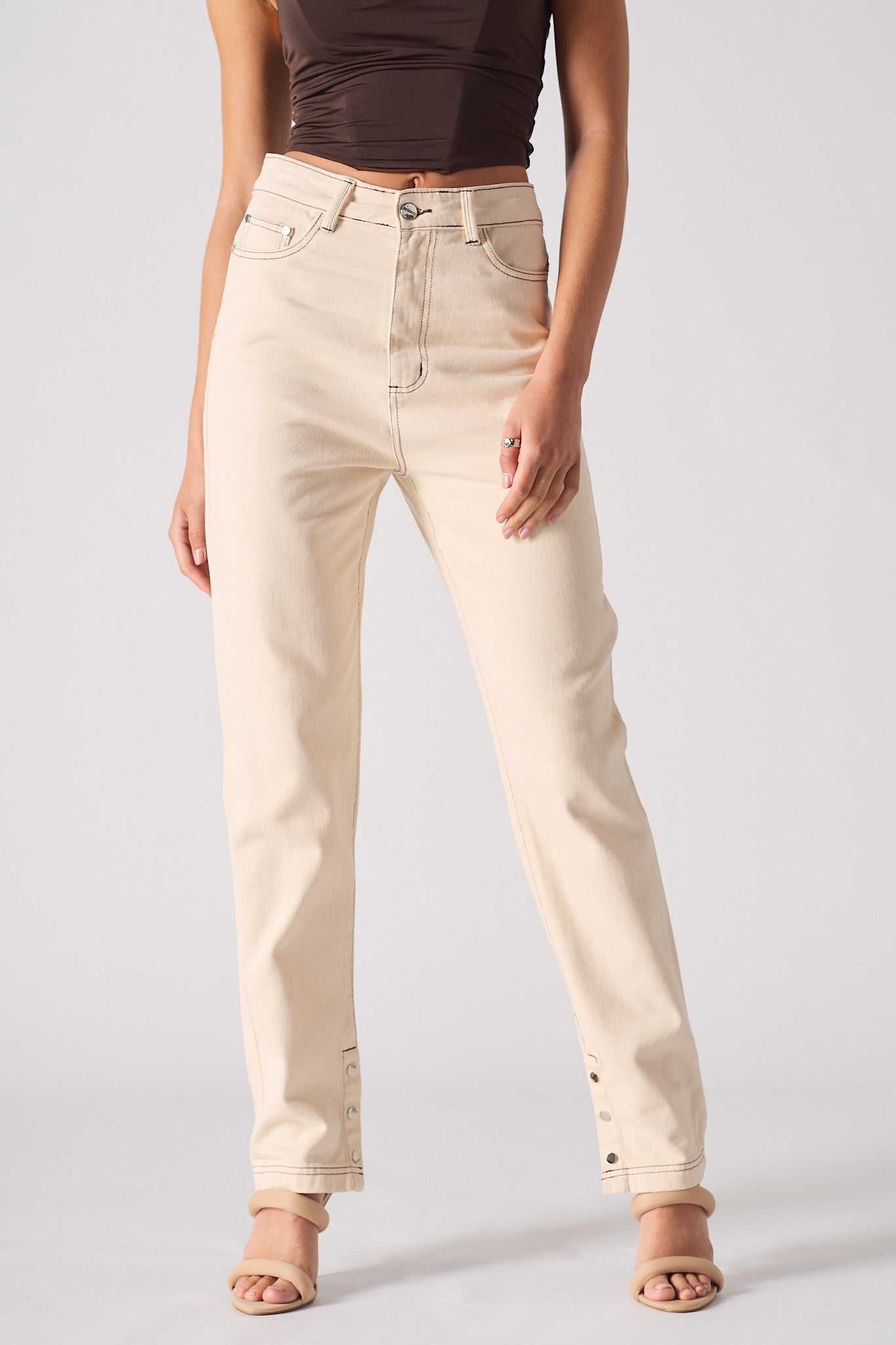 Person wearing beige jeans on a plain background