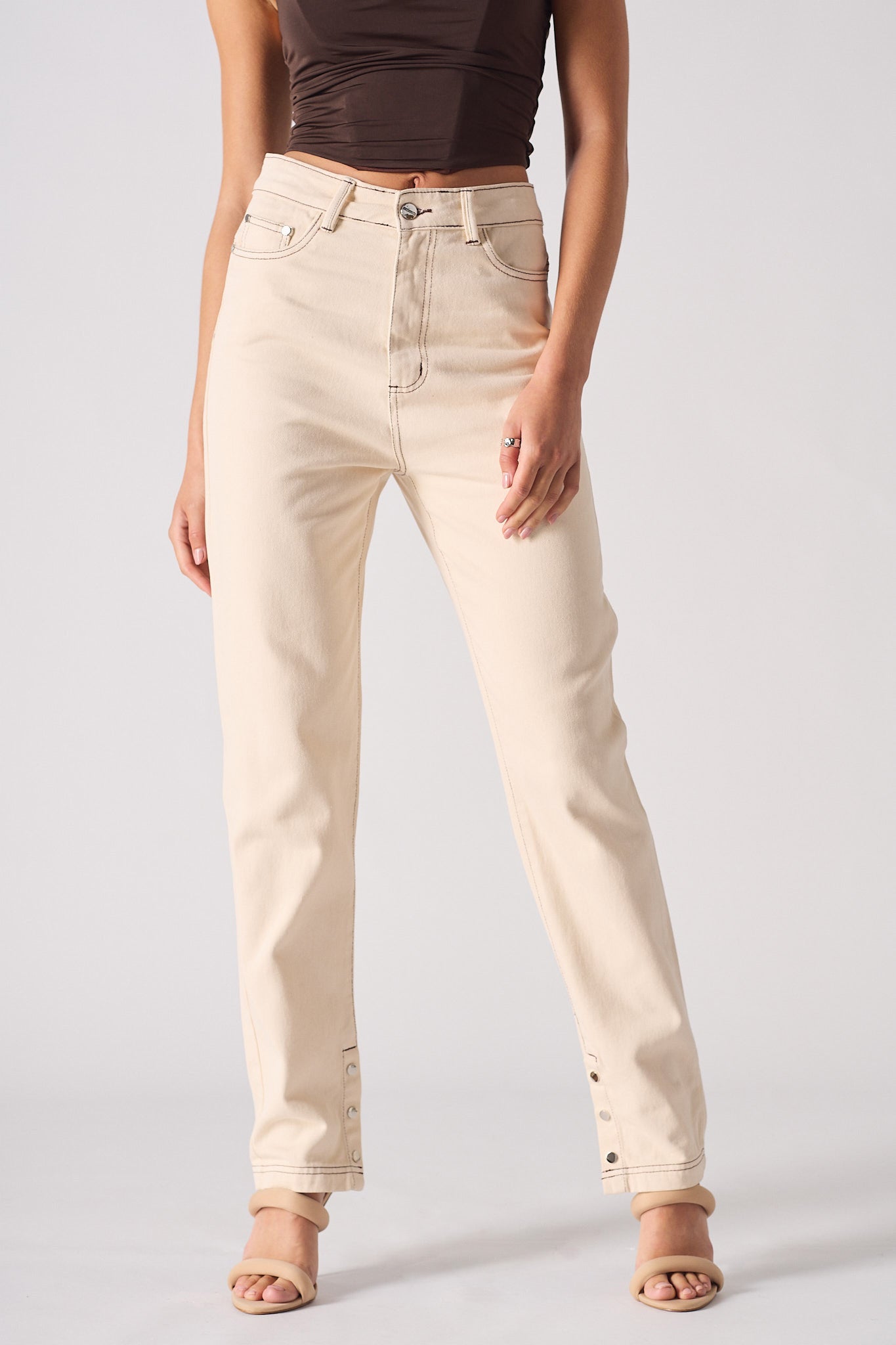 Person wearing beige jeans on a plain background
