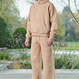 A model wearing beige joggers for men with a matching hoodie