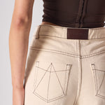 Beige pants with a brand label on a plain background