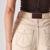 Beige pants with a brand label on a plain background