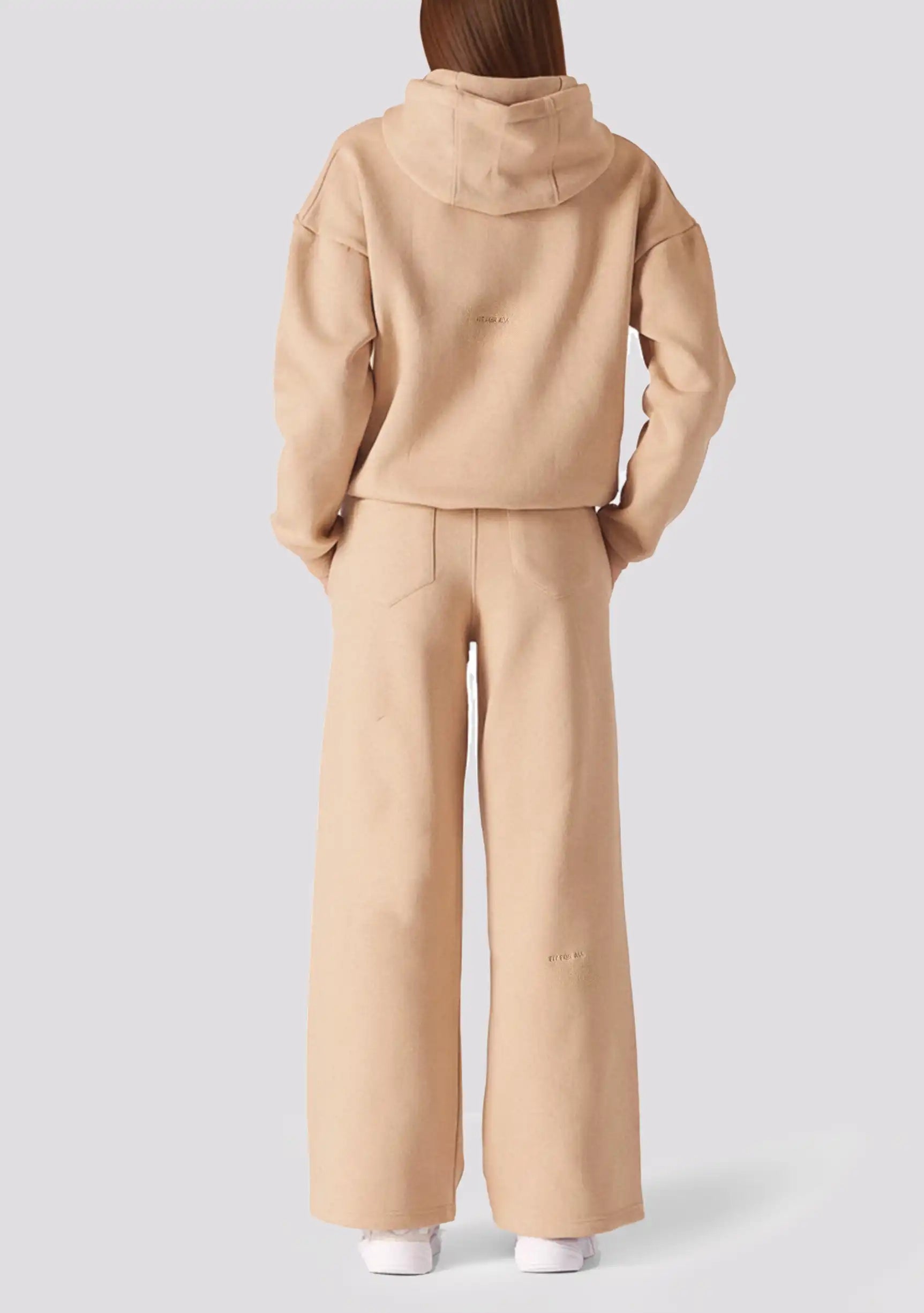 Rear view of a model wearing beige wide leg joggers and a matching hoodie