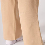 A detail shot of the wide leg opening and hem on the beige joggers