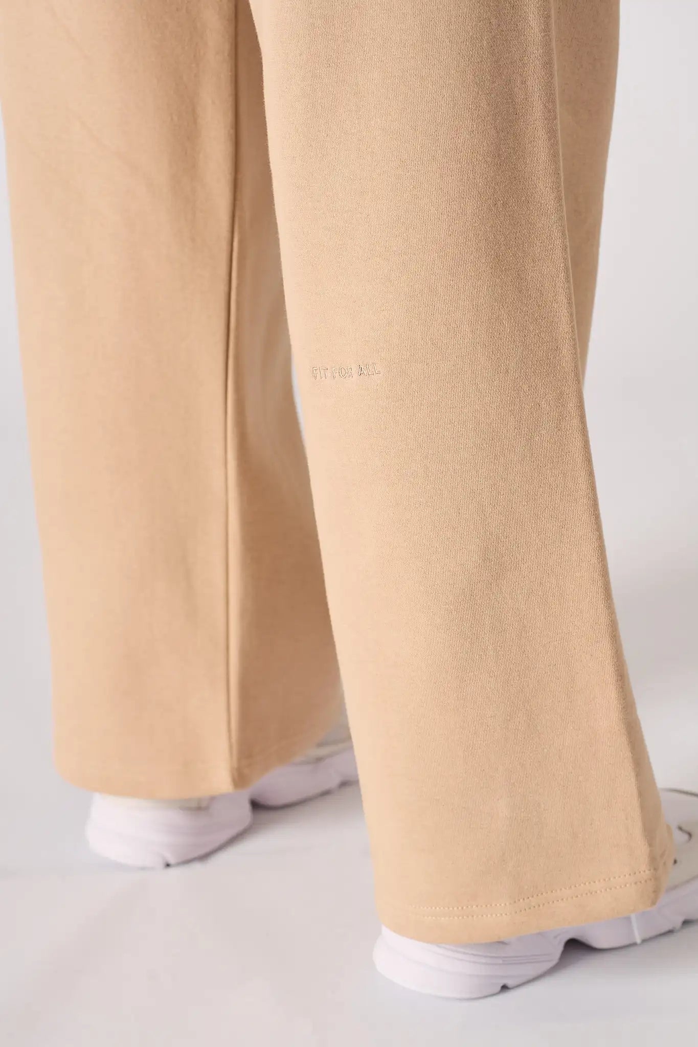 A detail shot of the wide leg opening and hem on the beige joggers