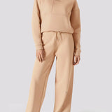 Full length shot of a woman in a matching set with beige wide leg joggers