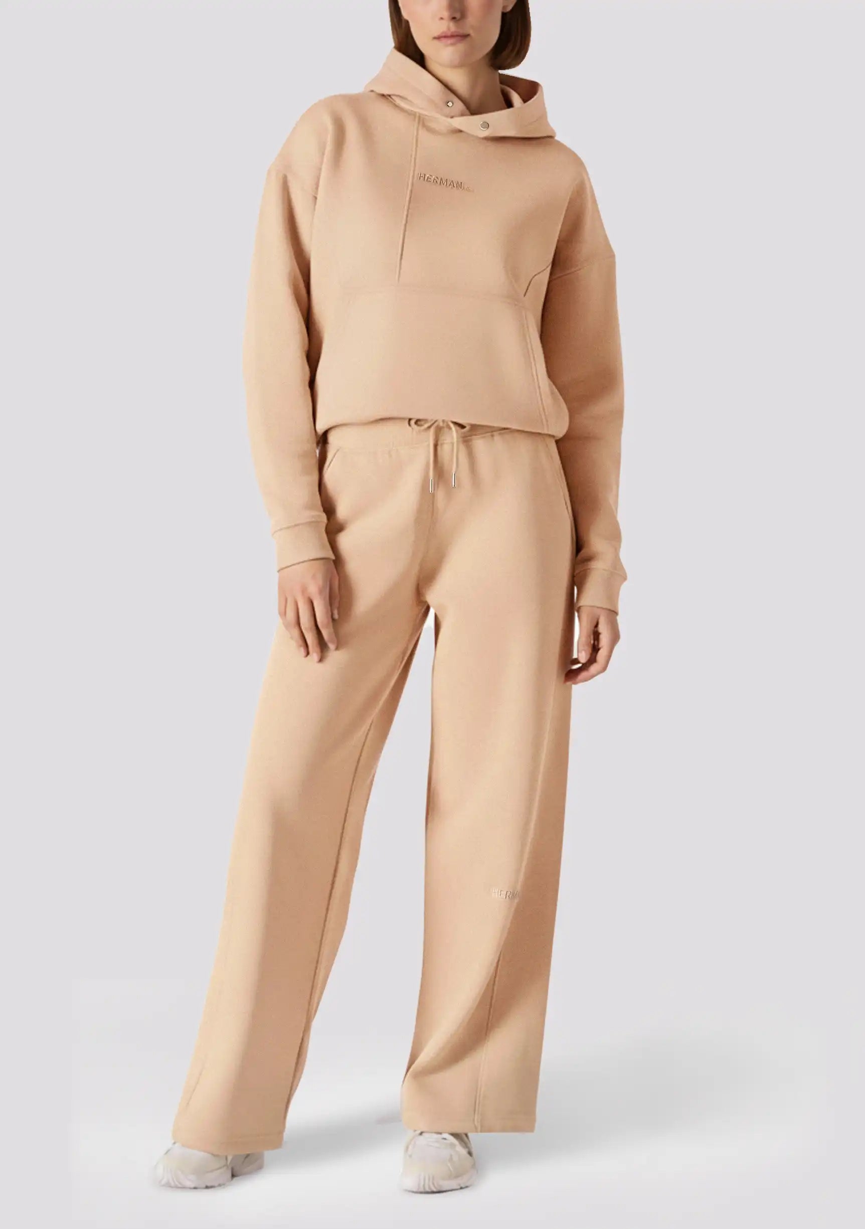 Full length shot of a woman in a matching set with beige wide leg joggers