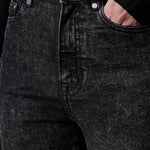 A close-up view of the black acid wash fabric and texture on the jeans