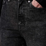 A close-up view of the black acid wash fabric and texture on the jeans