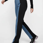 Person wearing black and blue pants with a white background