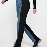Person wearing black and blue pants with a white background