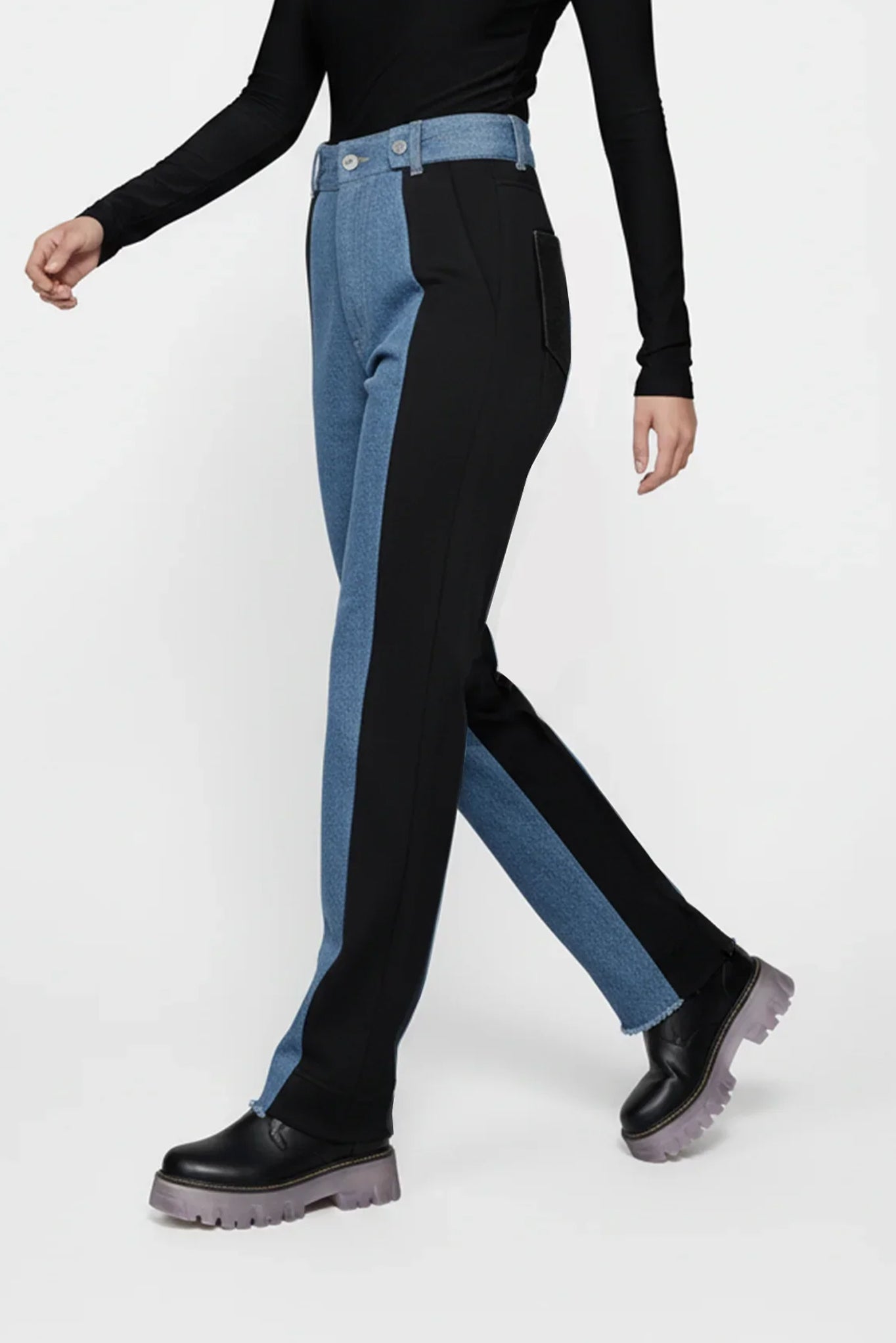 Person wearing black and blue pants with a white background