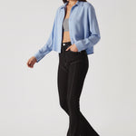 Model walking wearing black bootcut jeans, highlighting the unique front yoke and contrast stitching