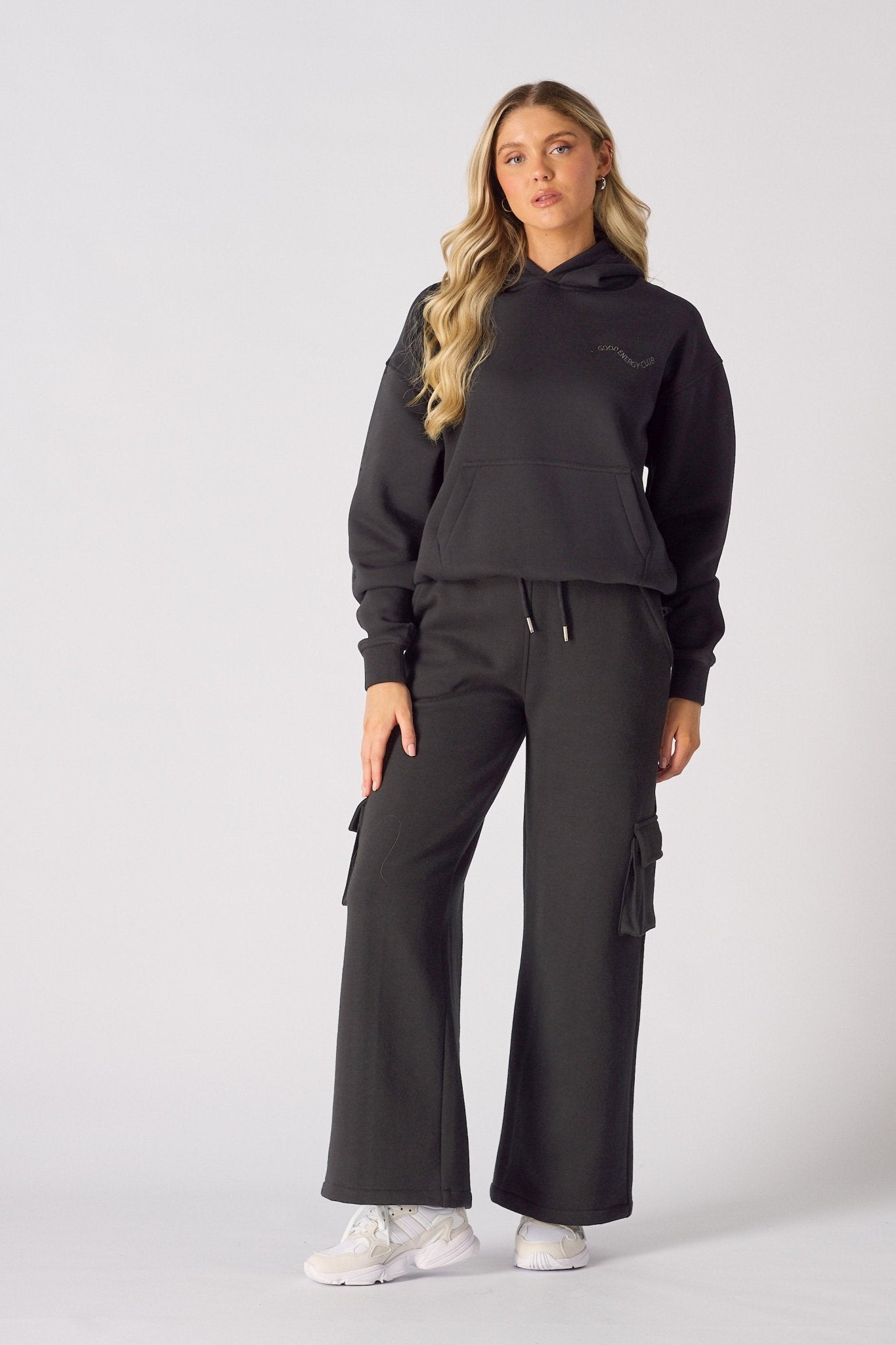 Detailed view of the three dimensional cargo pocket on black wide leg trousers