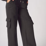 Close up shot of the cargo pocket and drawstring waist on black joggers