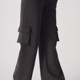 Side view of a woman wearing black wide leg cargo joggers with a utility pocket