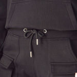Close up showing the adjustable ankle toggles on the black cargo trousers.