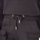 Close up showing the adjustable ankle toggles on the black cargo trousers.