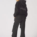 Back view showing the straight leg fit of the black cargo trousers.