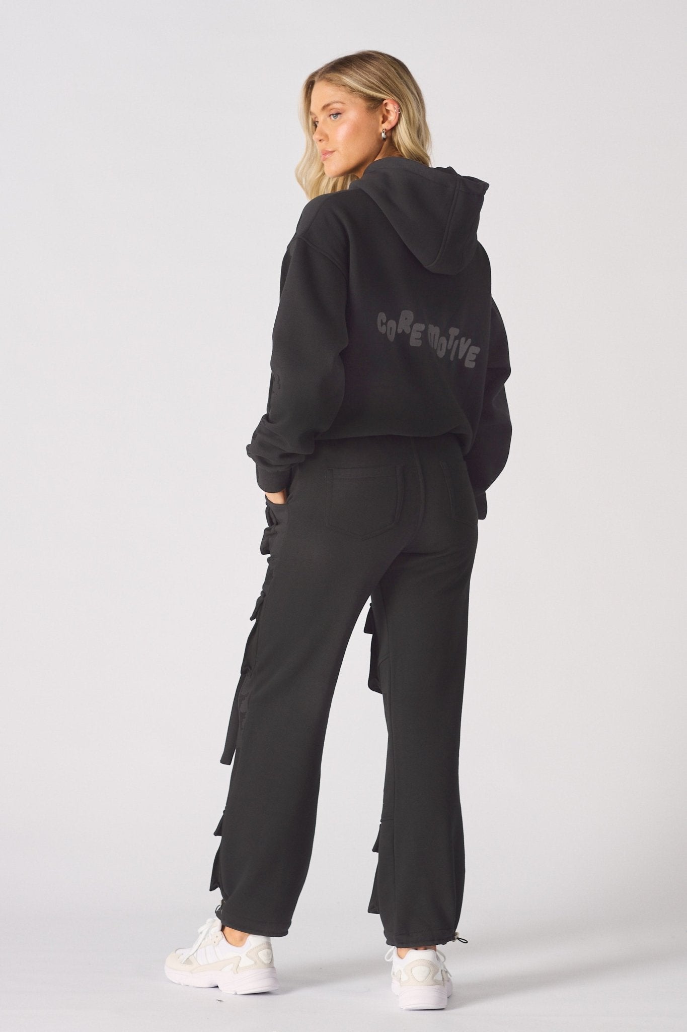 Back view showing the straight leg fit of the black cargo trousers.