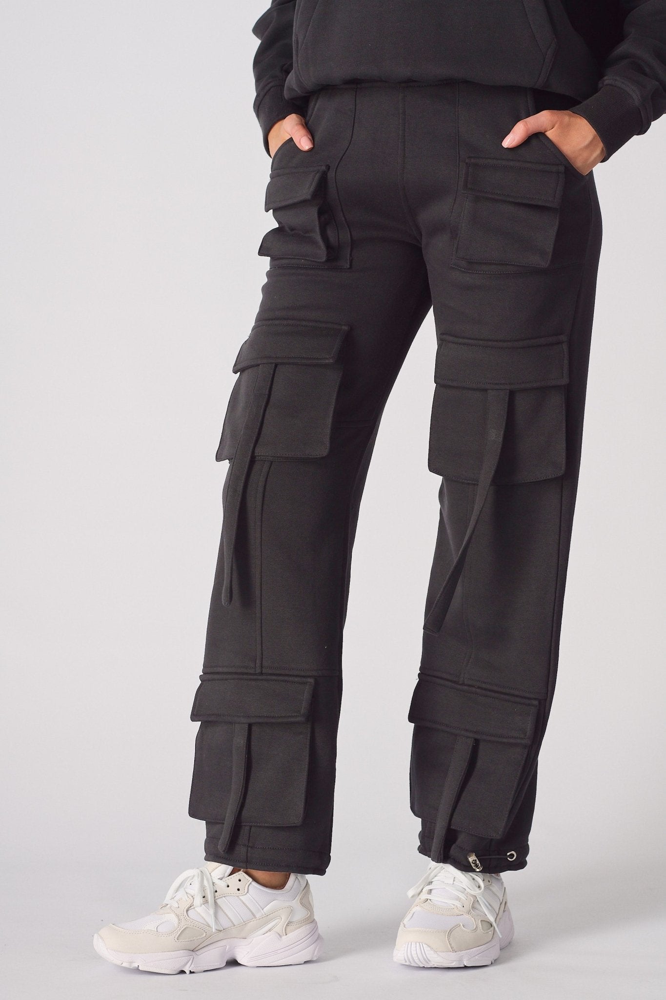 Close up of the multiple cargo pockets on black cargo trousers womens straight leg.